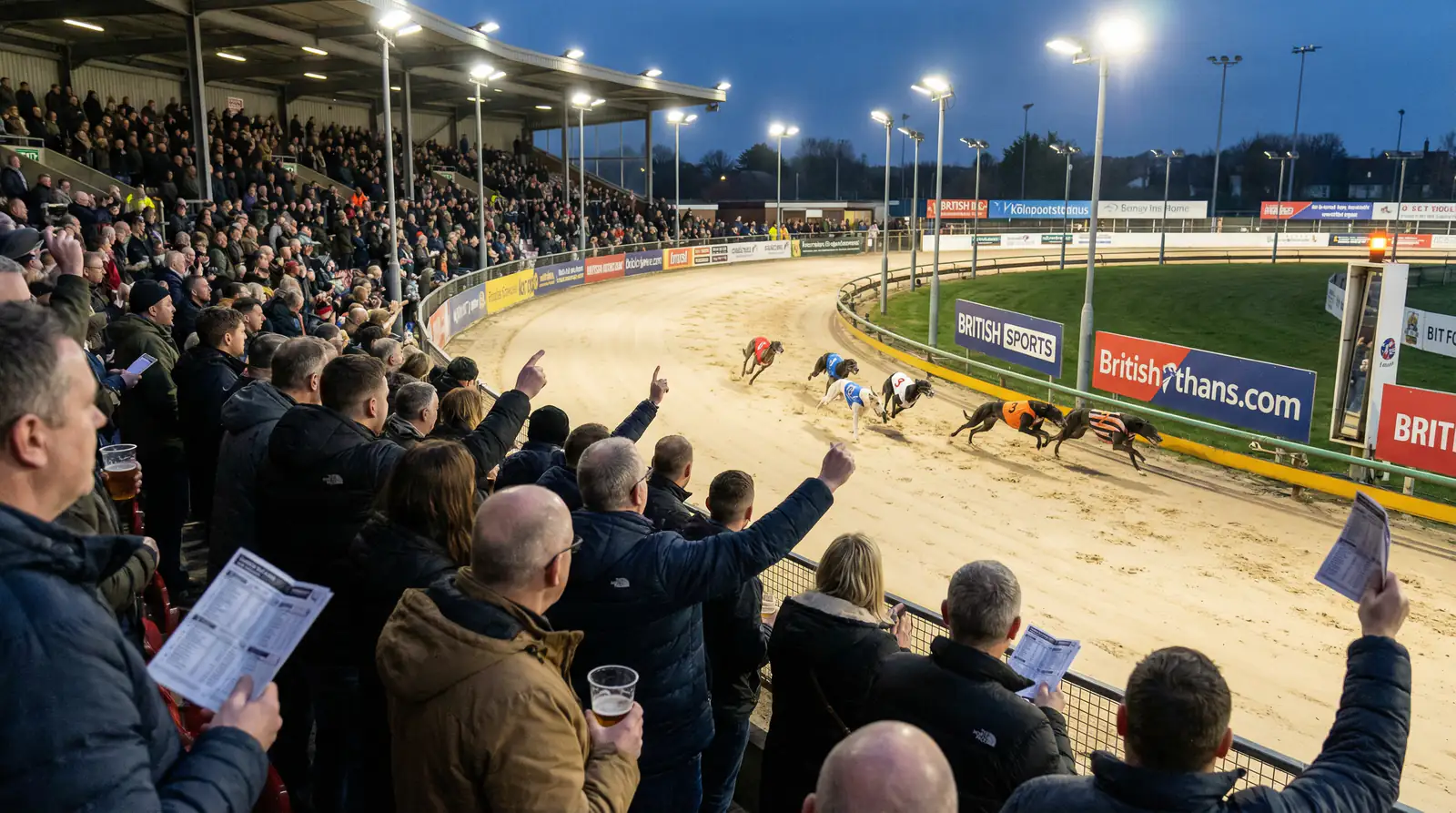 Monmore Green stadium under floodlights on a busy Saturday evening race night